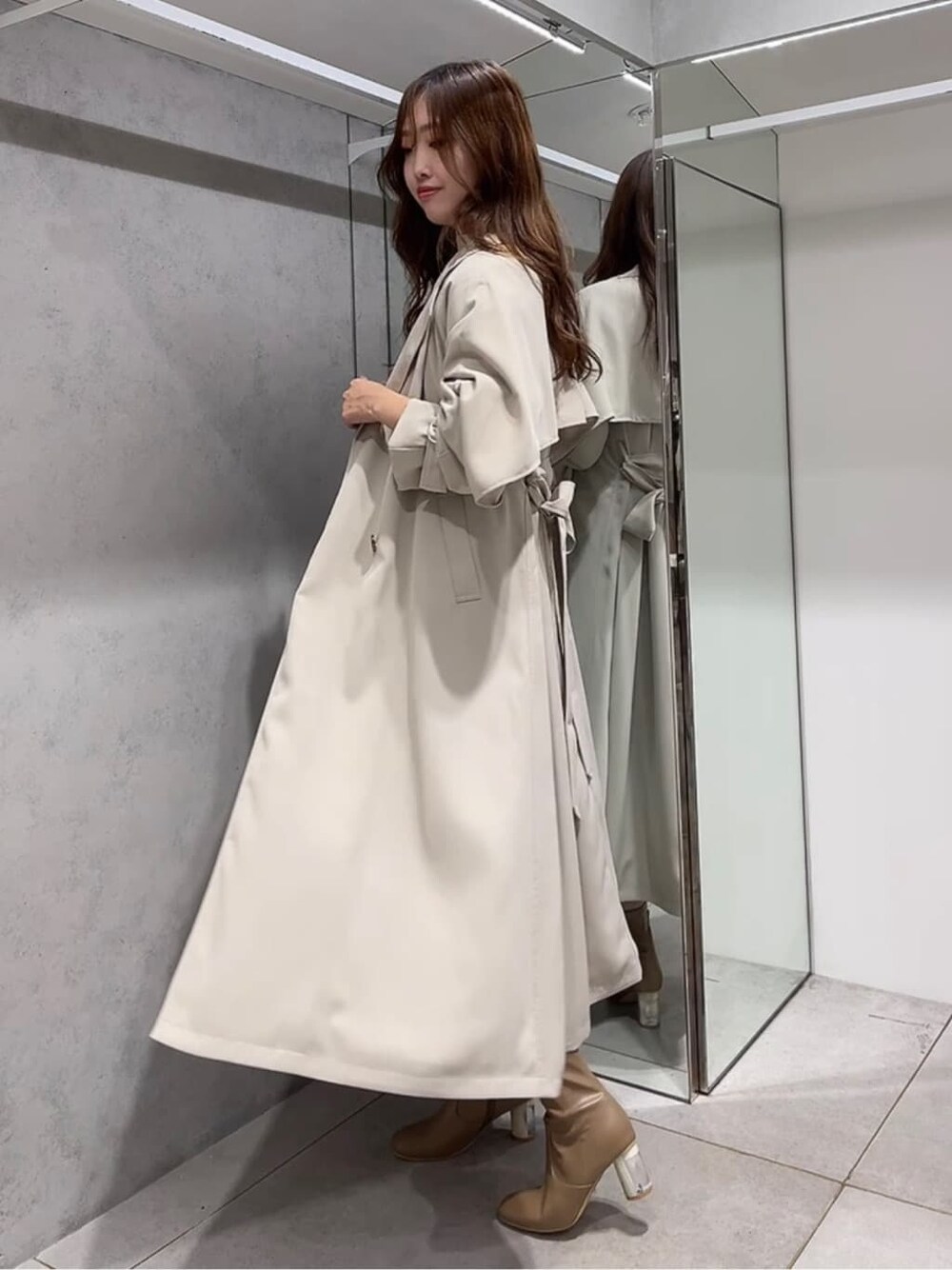 ベージュ系のトレンチコート、ベージュ系のトレンチコート、ホワイト系のワンピースを着用したレディースの秋コーディネートの2枚目の写真