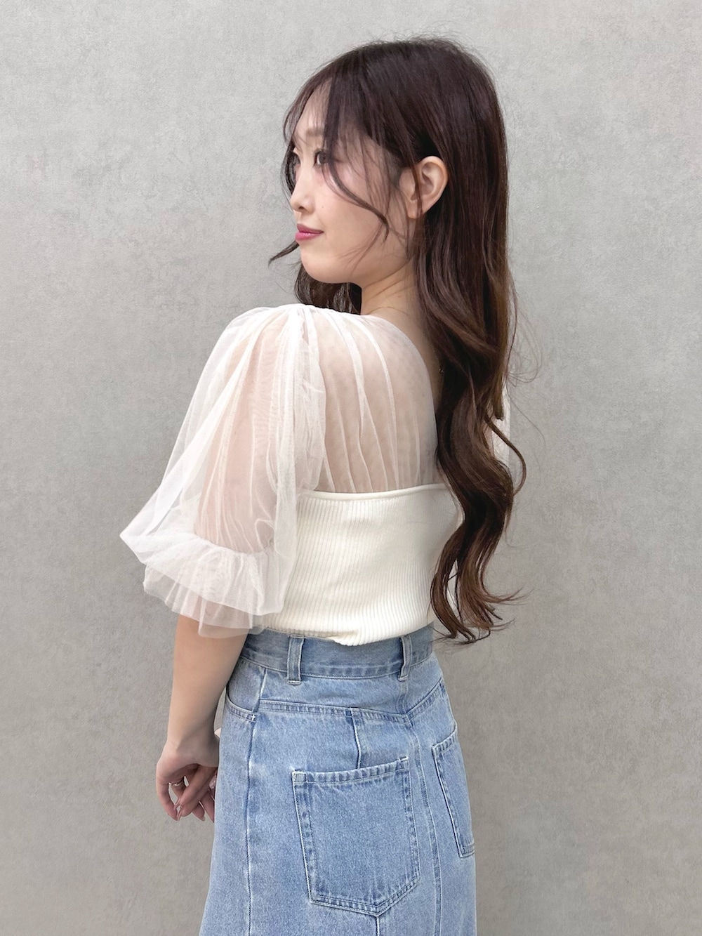 ホワイト系のニット/セーター、ブルー系のスカート、シルバー系のサンダルを着用したレディースの春コーディネートの5枚目の写真