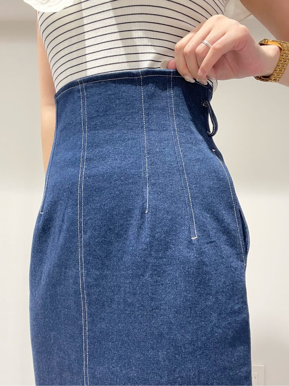 ブラック系のサンダル、ブラック系のトートバッグ、ブルー系のスカートを着用したレディースの夏コーディネートの7枚目の写真