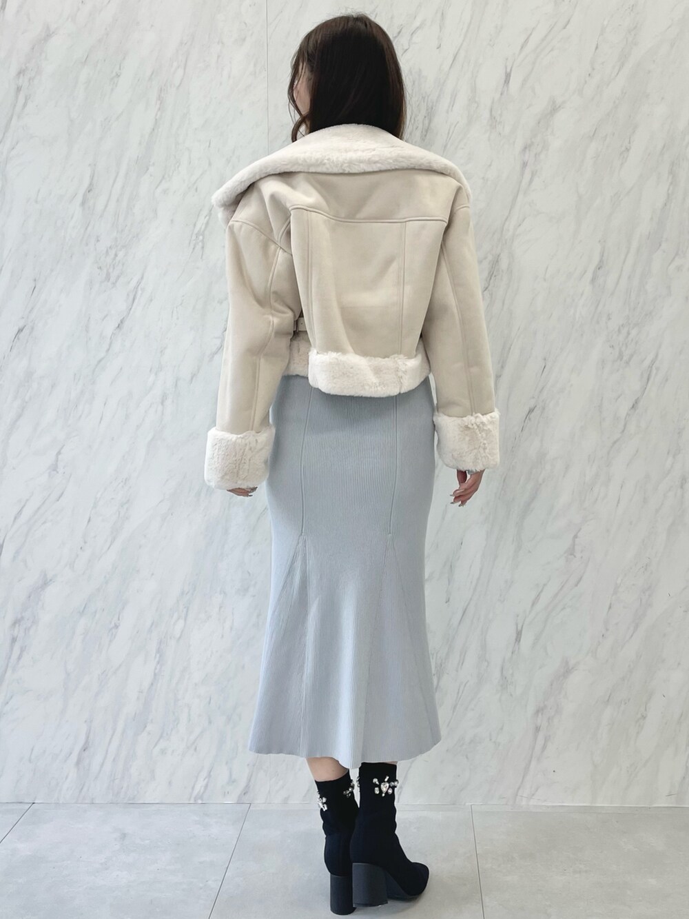 ブルー系のワンピース、ブラック系のブーツ、ベージュ系のムートンコートを着用したレディースの秋コーディネートの3枚目の写真