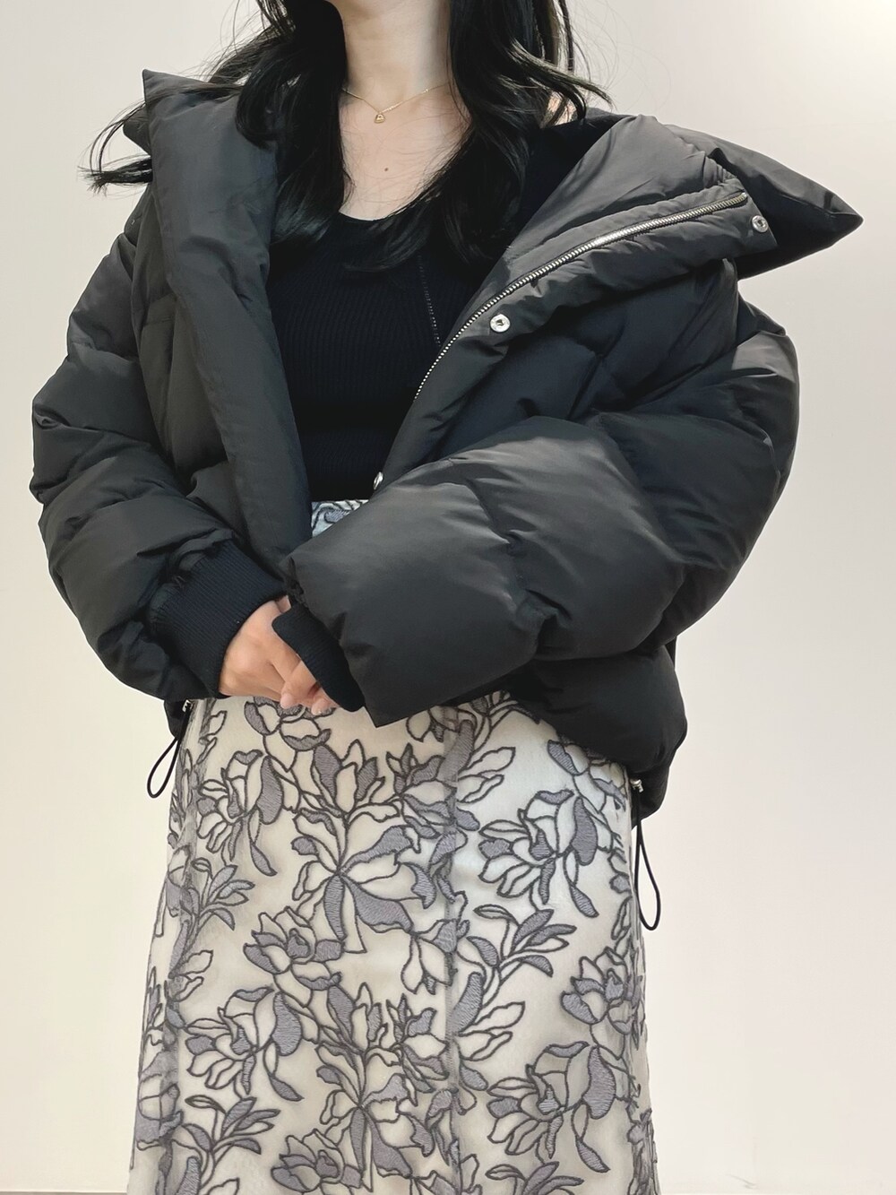 グレー系のスカート、ブラウン系のブーツ、ブラック系のダウンジャケット/コートを着用したレディースの冬コーディネートの5枚目の写真