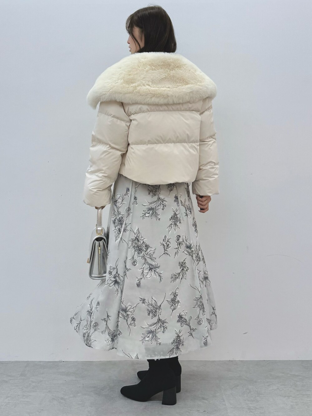 ホワイト系のダウンジャケット/コート、シルバー系のハンドバッグ、ブラック系のブーツを着用したレディースの秋コーディネートの4枚目の写真