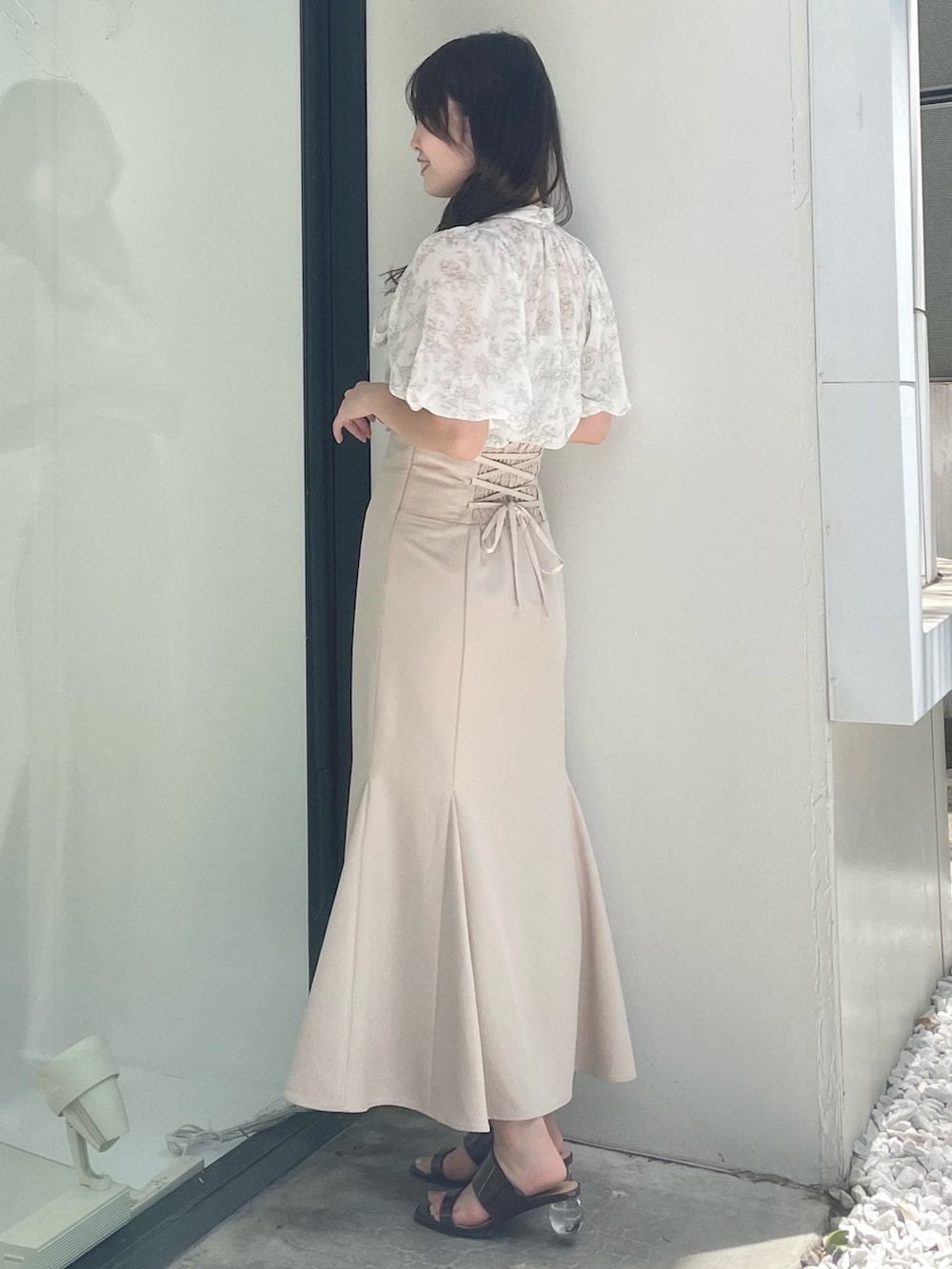 ベージュ系のシャツ/ブラウス、ベージュ系のスカート、ブラウン系のサンダルを着用したレディースの夏コーディネートの2枚目の写真