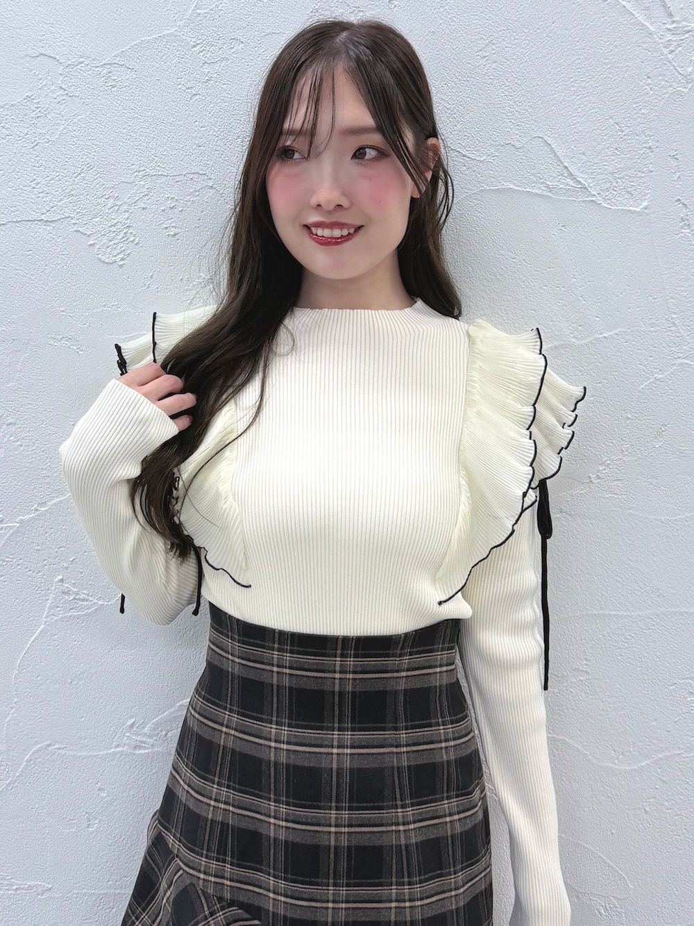 グレー系のスカート、ブラック系のブーツ、ホワイト系のニット/セーターを着用したレディースの秋コーディネートの4枚目の写真