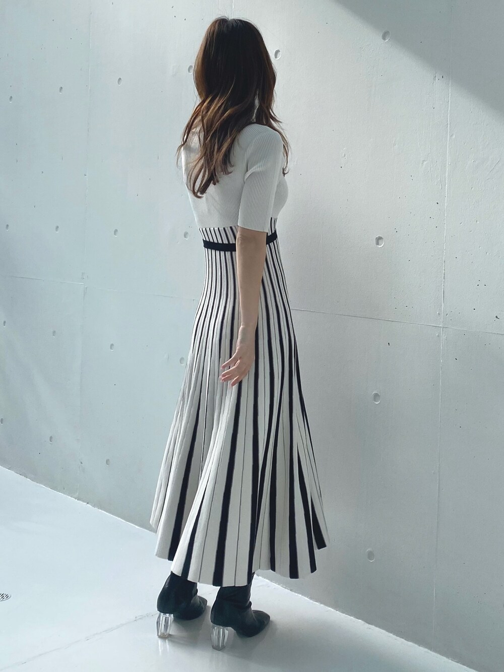 ホワイト系のワンピース、ベージュ系のライダースジャケットを着用したレディースの春コーディネートの7枚目の写真