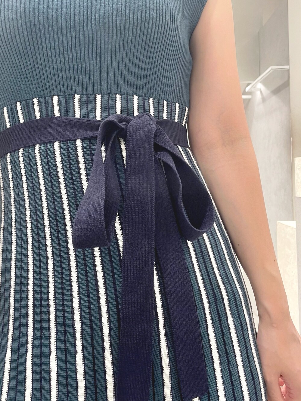 ブラック系のトートバッグ、ブラック系のサンダル、グリーン系のワンピースを着用したレディースの夏コーディネートの8枚目の写真