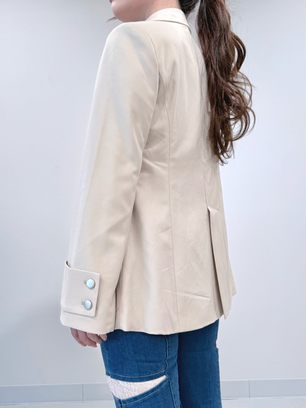 ブルー系のデニムパンツ、ホワイト系のテーラードジャケット、ホワイト系のシャツ/ブラウスを着用したレディースの春コーディネートの5枚目の写真