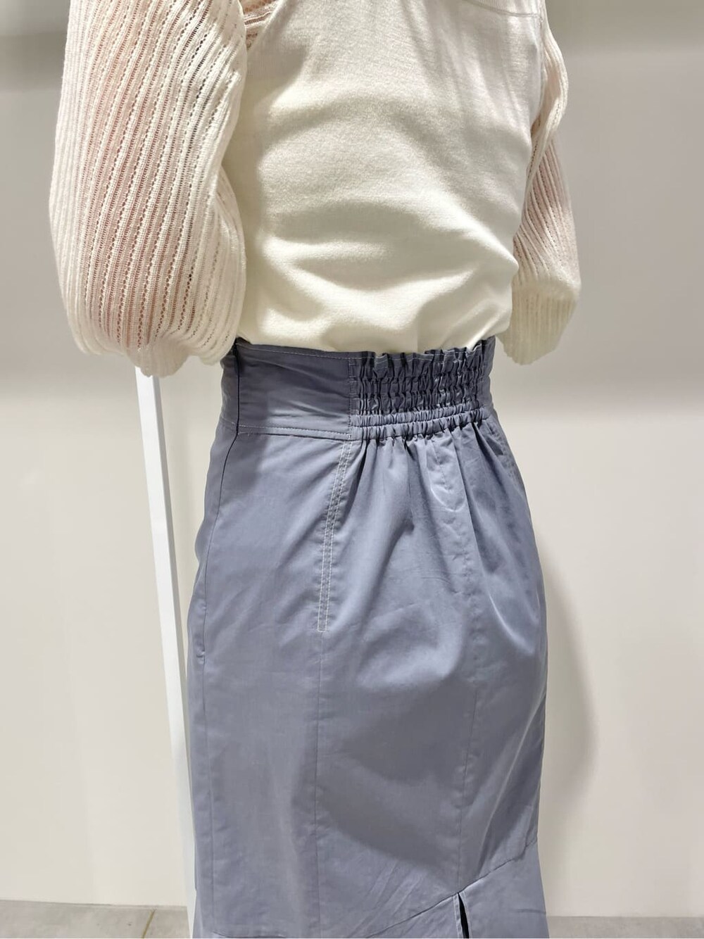 ブルー系のスカート、ホワイト系のニット/セーターを着用したレディースの春コーディネートの7枚目の写真