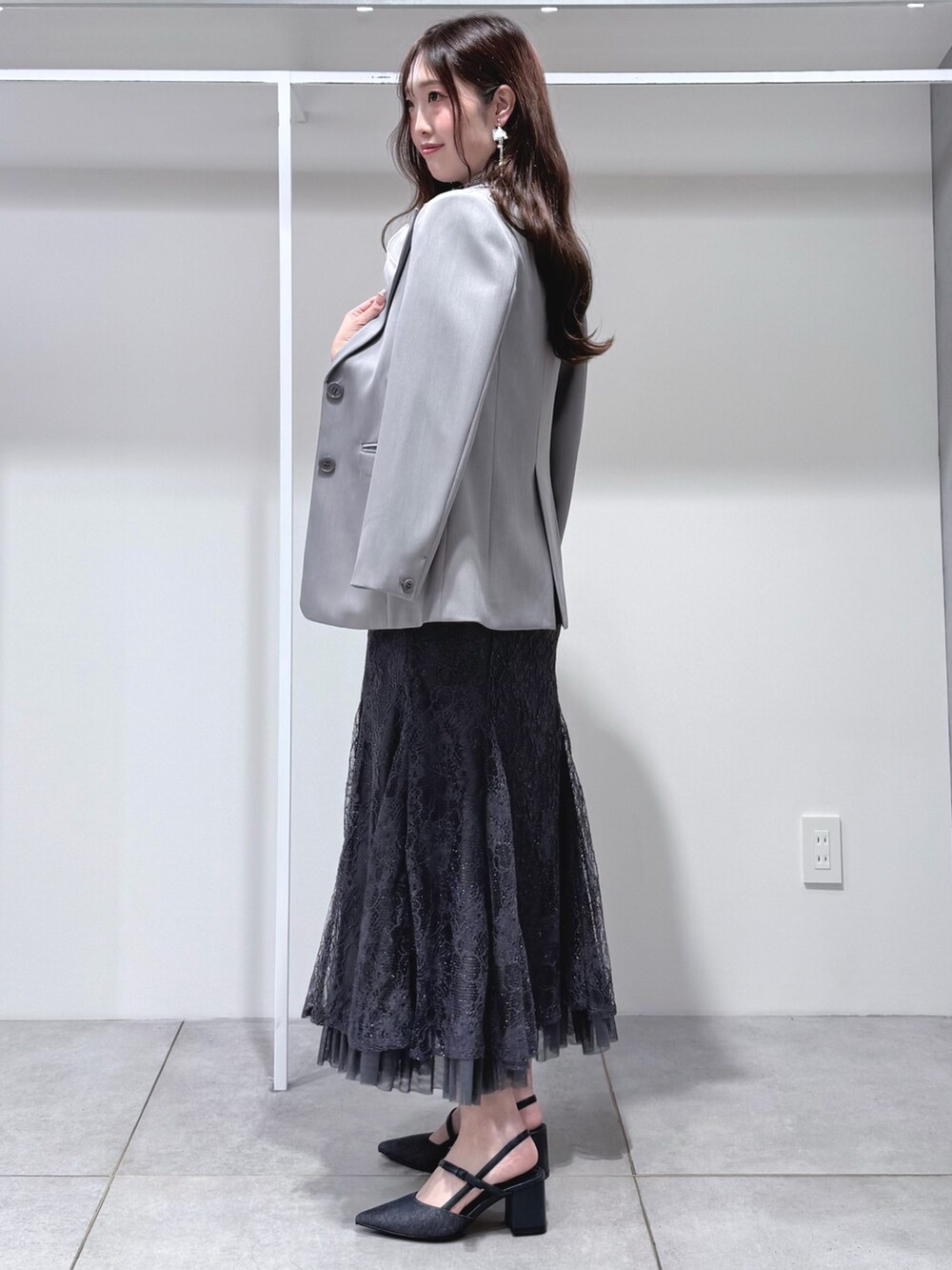 グレー系のシャツ/ブラウス、グレー系のスカート、ブルー系のパンプスを着用したレディースの春コーディネートの3枚目の写真