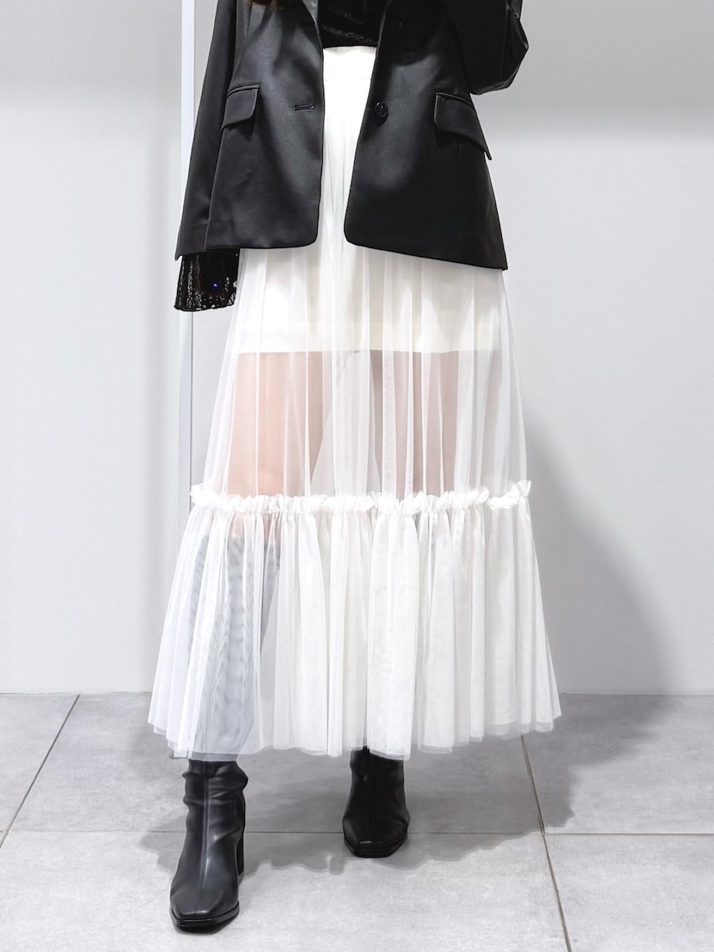 ブラック系のテーラードジャケット、ブラック系のTシャツ/カットソー、ブラック系のブーツを着用したレディースの秋コーディネートの8枚目の写真