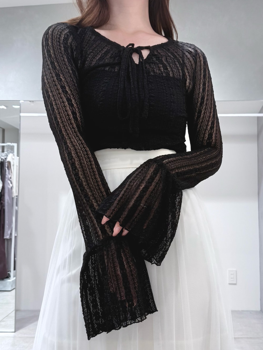 ブラック系のブーツ、ホワイト系のスカート、ブラック系のTシャツ/カットソーを着用したレディースの秋コーディネートの5枚目の写真