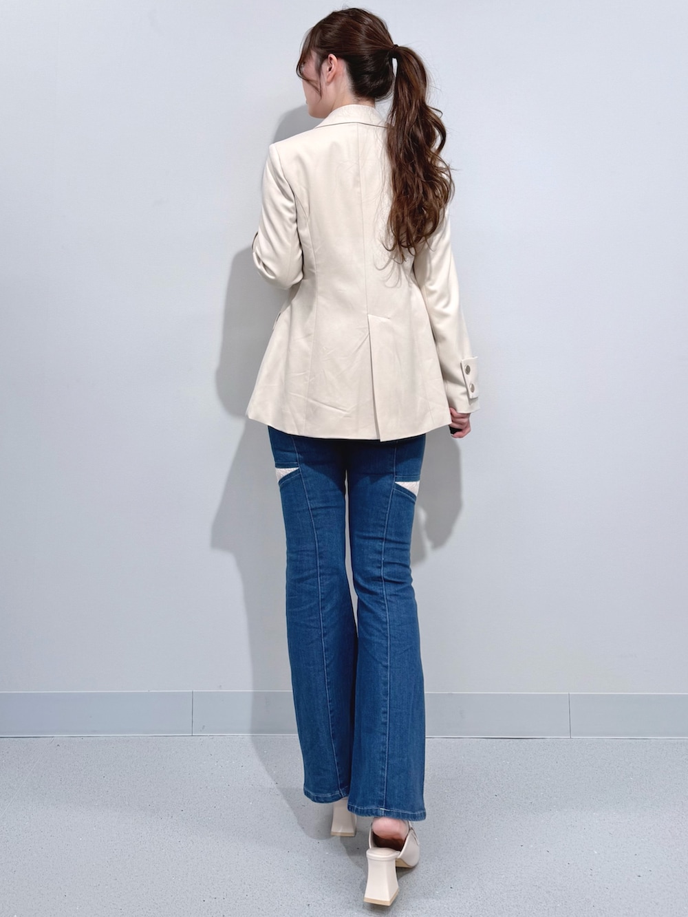 ブルー系のデニムパンツ、ホワイト系のテーラードジャケット、ホワイト系のシャツ/ブラウスを着用したレディースの春コーディネートの3枚目の写真