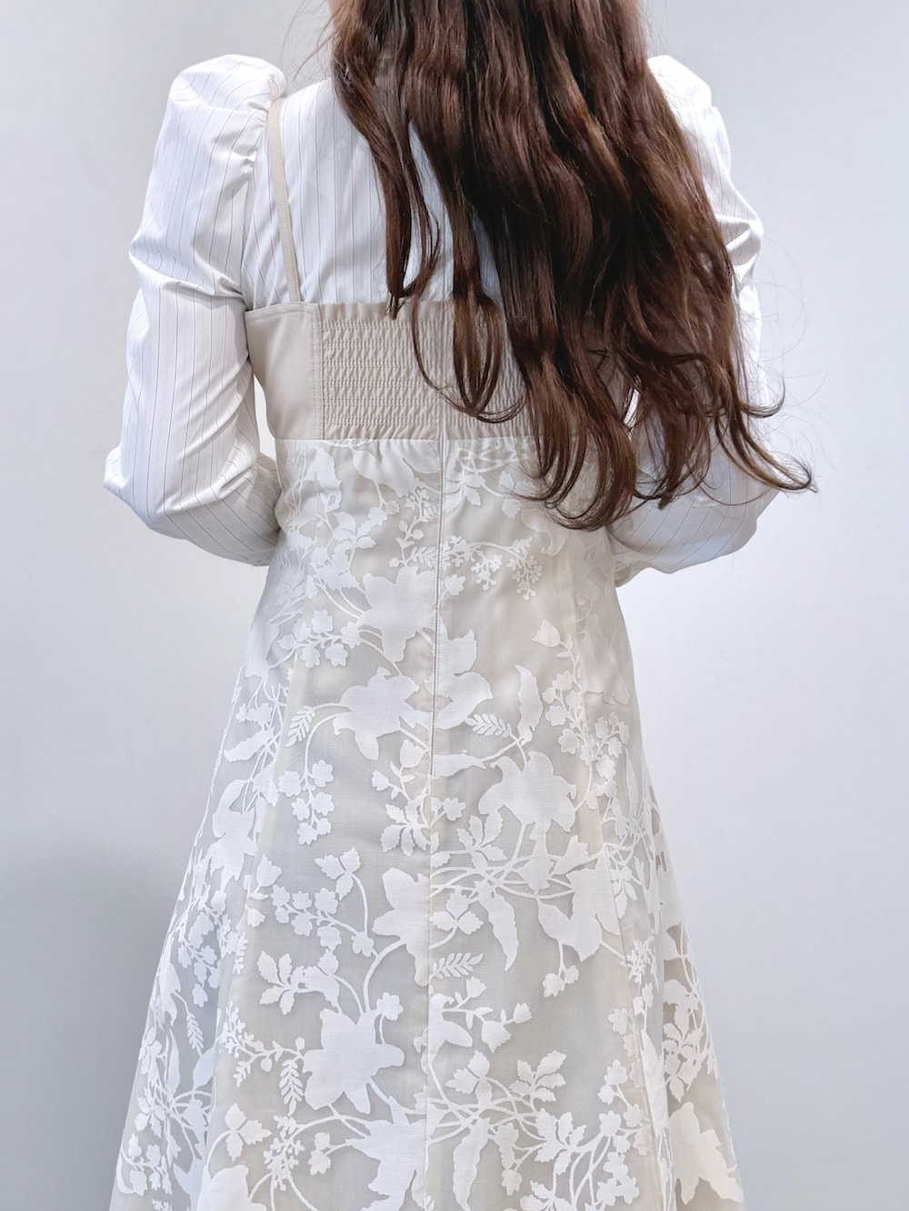 ベージュ系のワンピース、ホワイト系のパンプスを着用したレディースの冬コーディネートの7枚目の写真