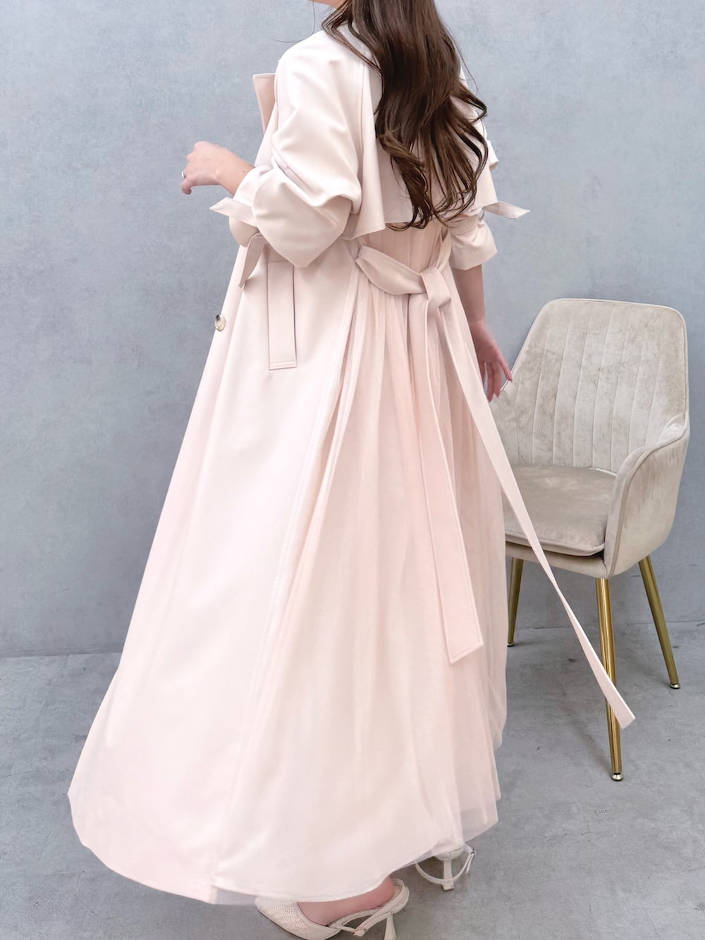 ホワイト系のワンピース、ピンク系のトレンチコート、ホワイト系のパンプスを着用したレディースの冬コーディネートの7枚目の写真