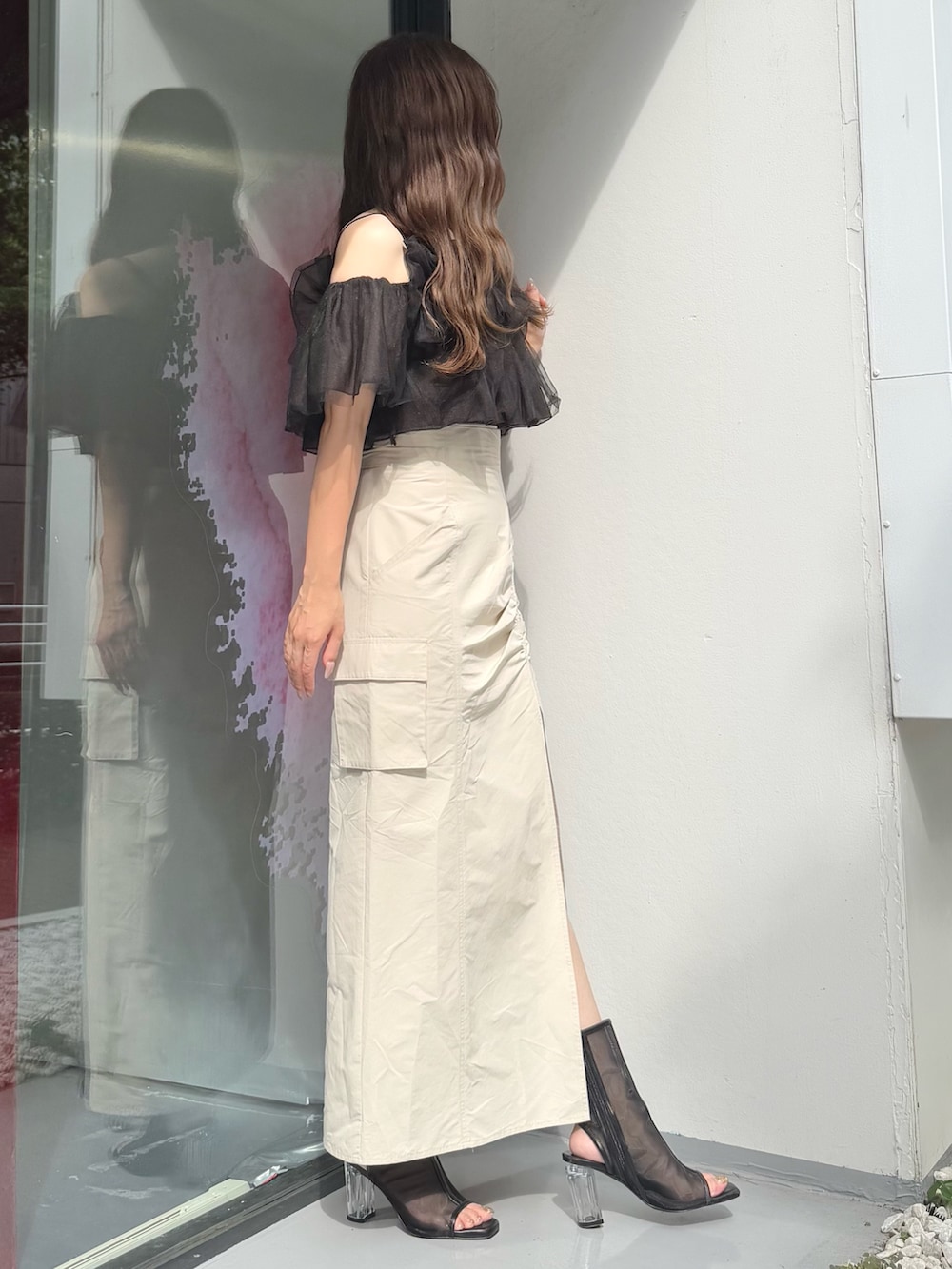 ホワイト系のスカート、ブラック系のシャツ/ブラウスを着用したレディースの夏コーディネートの3枚目の写真