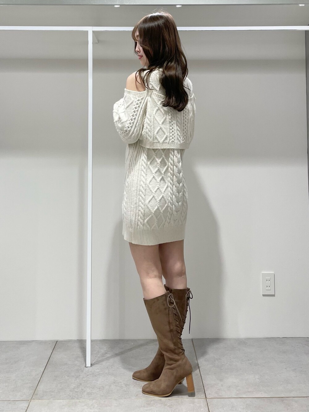 ホワイト系のその他アウター、ホワイト系のワンピース、ブラウン系のブーツを着用したレディースの冬コーディネートの8枚目の写真