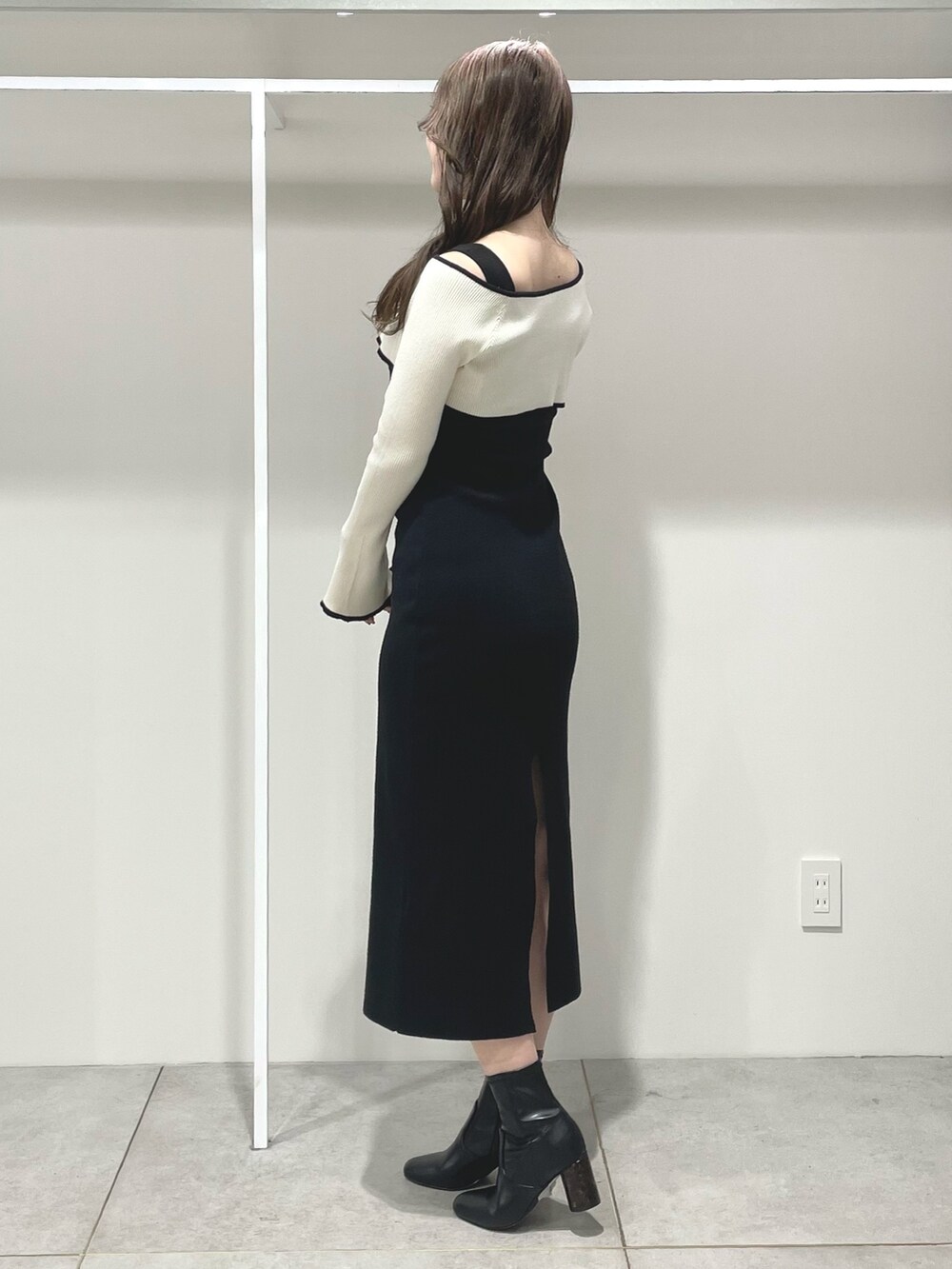 ブラック系のワンピース、ブラック系のブーツを着用したレディースの冬コーディネートの3枚目の写真