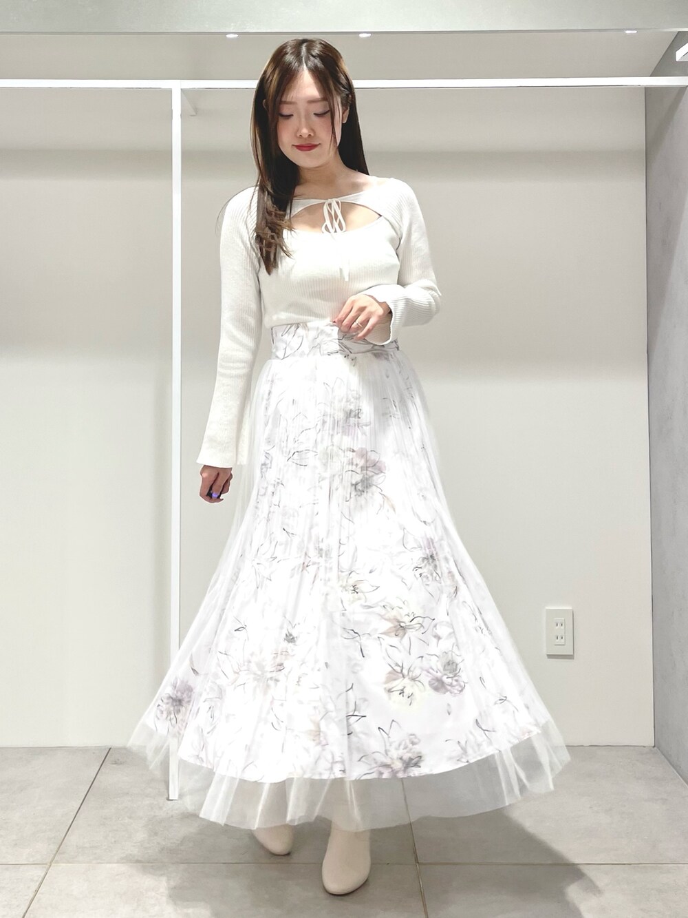 パープル系のトレンチコート、ホワイト系のニット/セーター、ピンク系のスカートを着用したレディースの春コーディネートの4枚目の写真