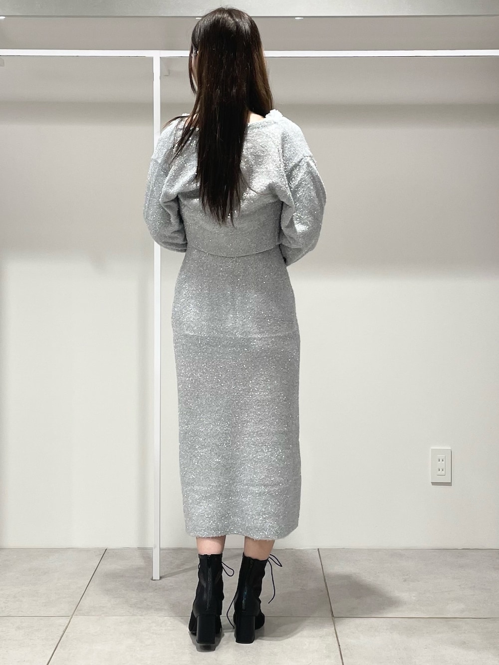 シルバー系のワンピース、ブラック系のショルダーバッグ、ブラック系のブーツを着用したレディースの秋コーディネートの4枚目の写真