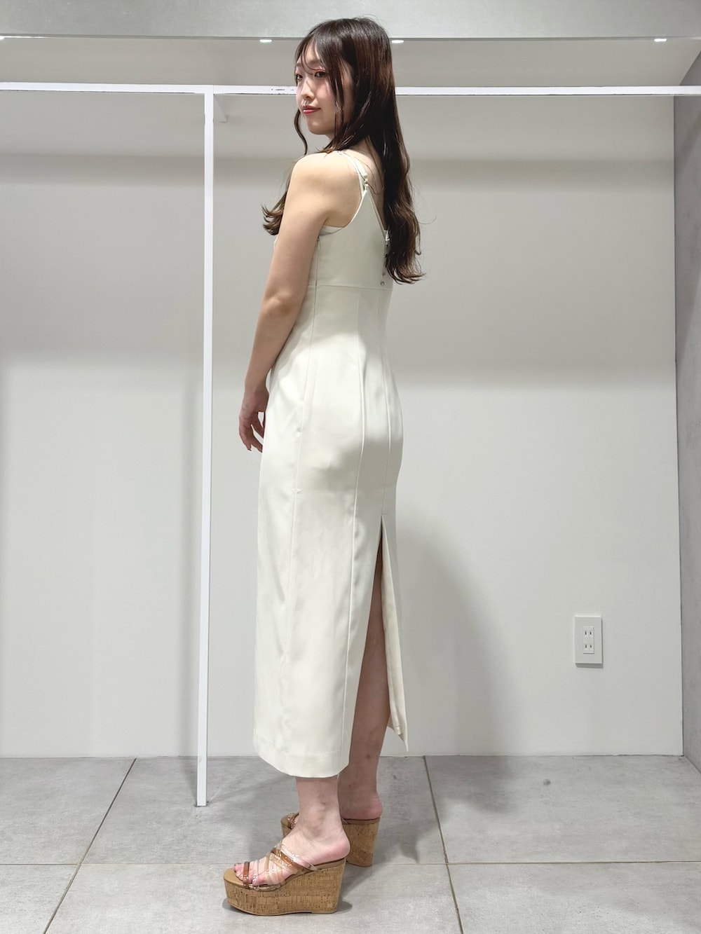 ホワイト系のワンピース、ベージュ系のサンダルを着用したレディースの春コーディネートの2枚目の写真