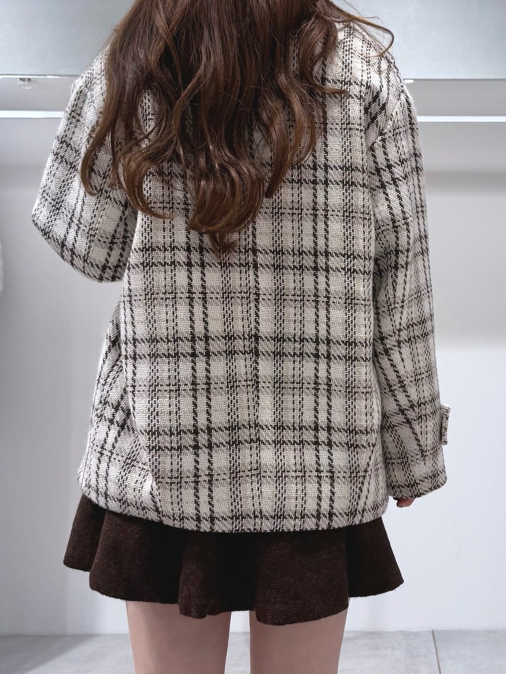 ブラウン系のワンピース、ブラウン系のブーツ、ホワイト系のその他アウターを着用したレディースの秋コーディネートの7枚目の写真