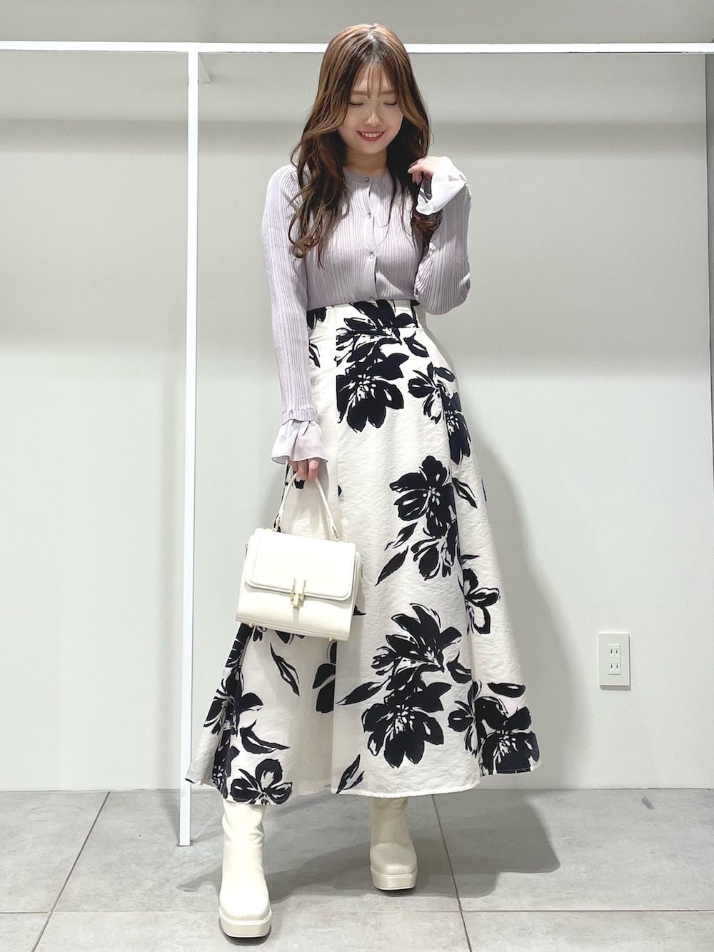 ホワイト系のスカート、ホワイト系のチェスターコート、ベージュ系のカーディガン/ボレロを着用したレディースの秋コーディネートの4枚目の写真