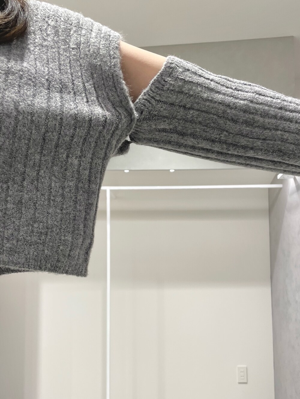 ブラック系のスカート、ブラック系のブーツ、グレー系のニット/セーターを着用したレディースの冬コーディネートの7枚目の写真