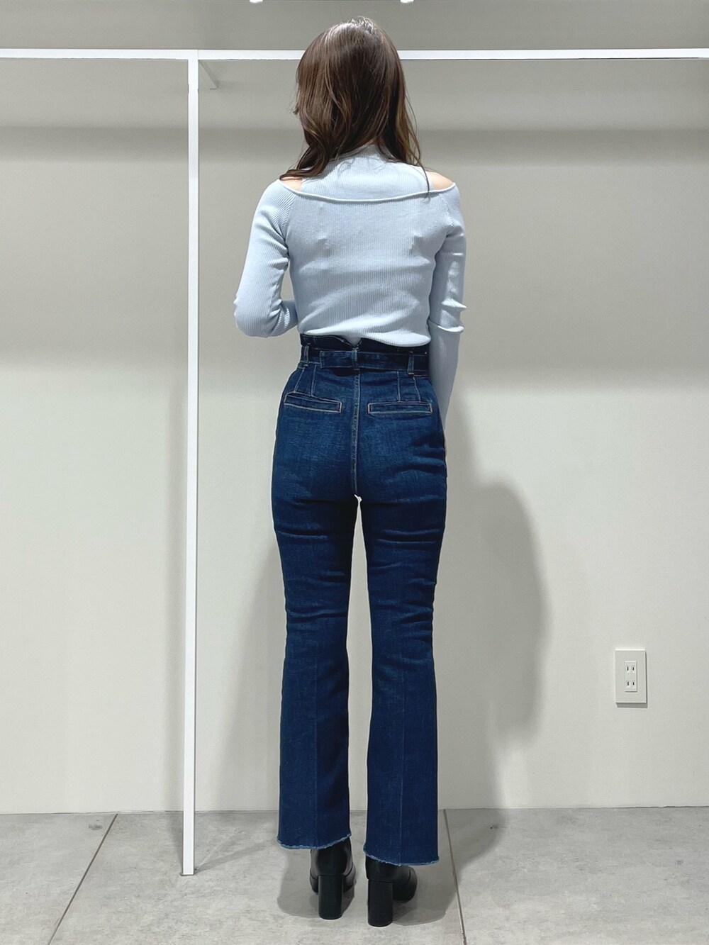 ホワイト系のハンドバッグ、ブラック系のブーツ、ブルー系のニット/セーターを着用したレディースの冬コーディネートの9枚目の写真