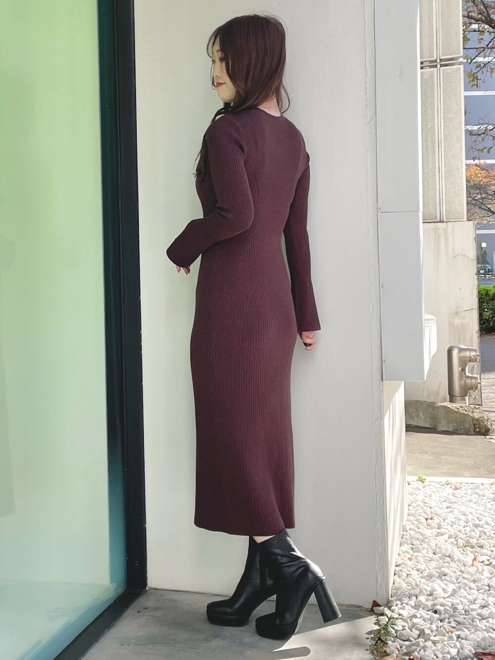 ブラック系のダウンジャケット/コート、ブラウン系のワンピース、ブラック系のブーツを着用したレディースの冬コーディネートの6枚目の写真