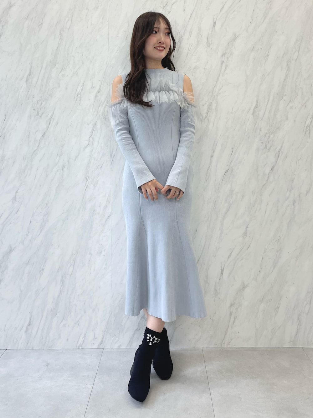 ブルー系のワンピース、ブラック系のブーツ、ベージュ系のムートンコートを着用したレディースの秋コーディネートの6枚目の写真