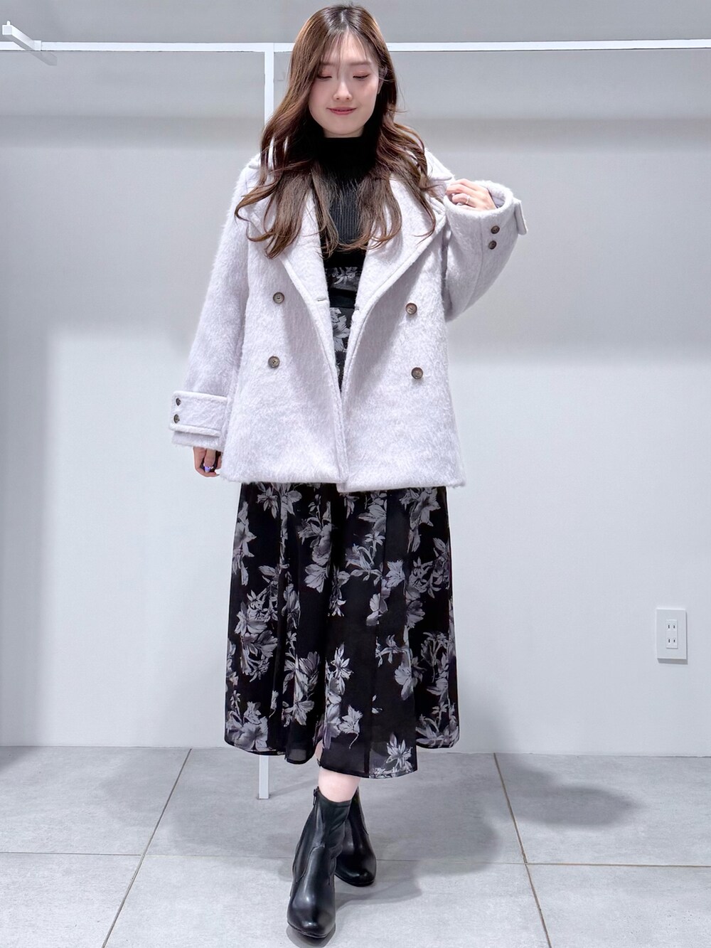 グレー系のその他アウター、ブラック系のワンピース、ブラック系のブーツを着用したレディースの冬コーディネートの2枚目の写真