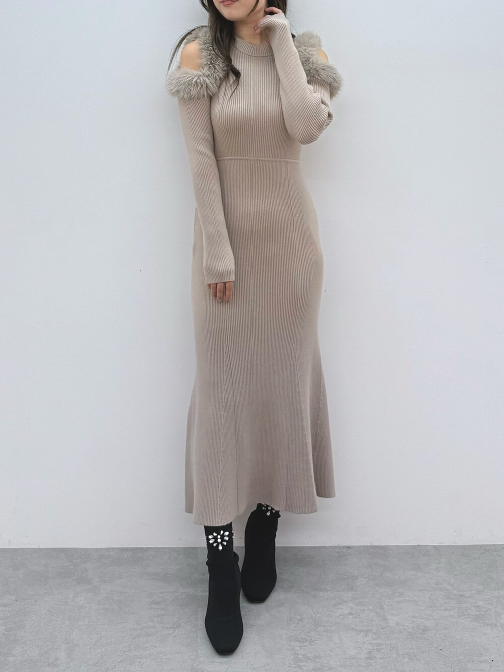 ベージュ系のワンピース、ブラック系のブーツを着用したレディースの秋コーディネートの2枚目の写真