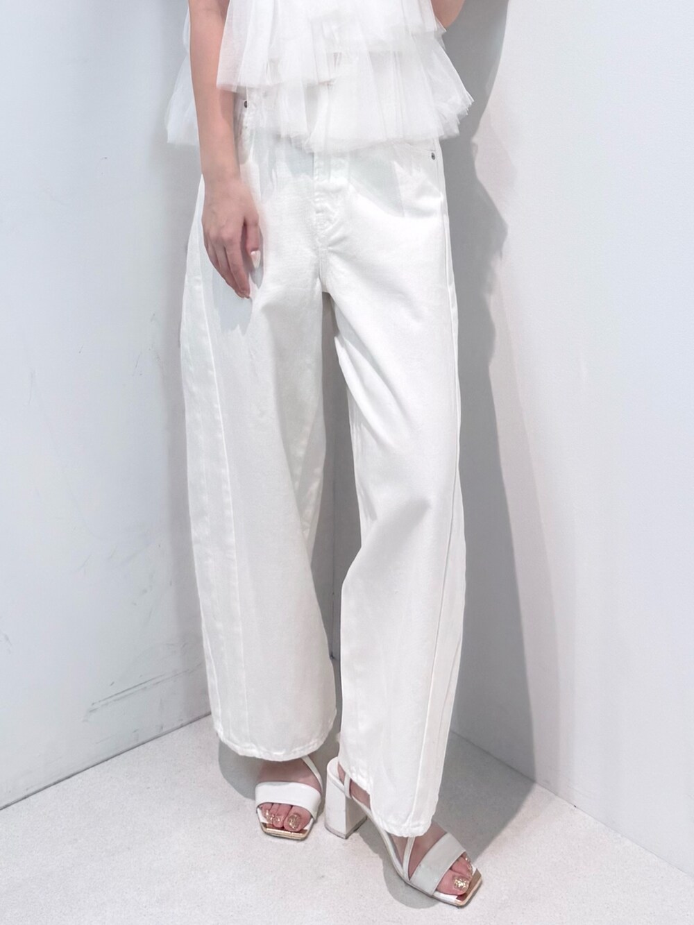 ホワイト系のデニムパンツ、ホワイト系のサンダル、ホワイト系のTシャツ/カットソーを着用したレディースの春コーディネートの7枚目の写真