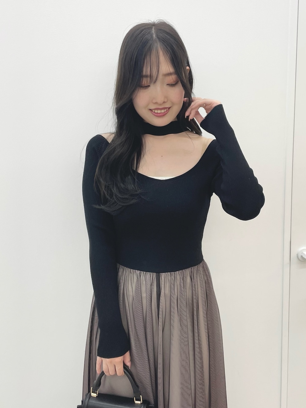 ブラック系のワンピース、ブラック系のハンドバッグ、ブラック系のブーツを着用したレディースの秋コーディネートの5枚目の写真