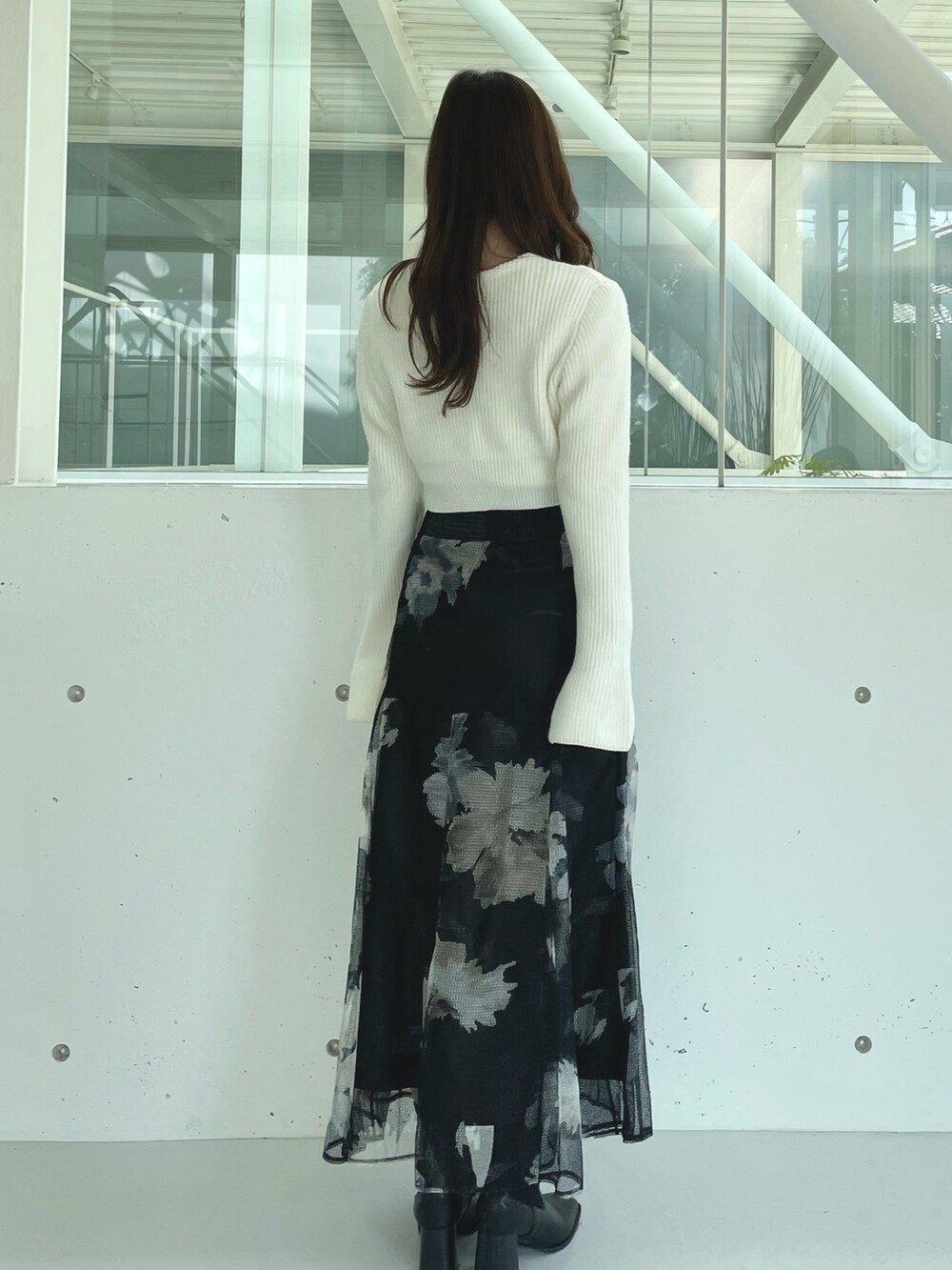 ブラック系のスカート、ブラック系のブーツ、ホワイト系のカーディガン/ボレロを着用したレディースの秋コーディネートの5枚目の写真