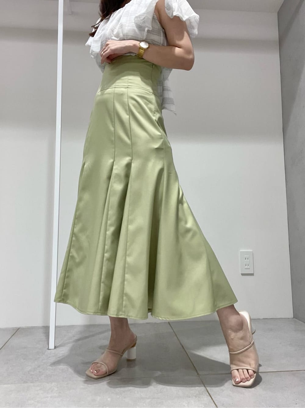 ホワイト系のキャミソール、グリーン系のスカート、ベージュ系のサンダルを着用したレディースの夏コーディネートの7枚目の写真