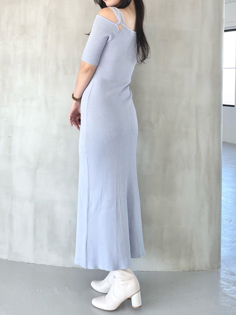 ブルー系のワンピース、ホワイト系のブーツを着用したレディースの秋コーディネートの2枚目の写真