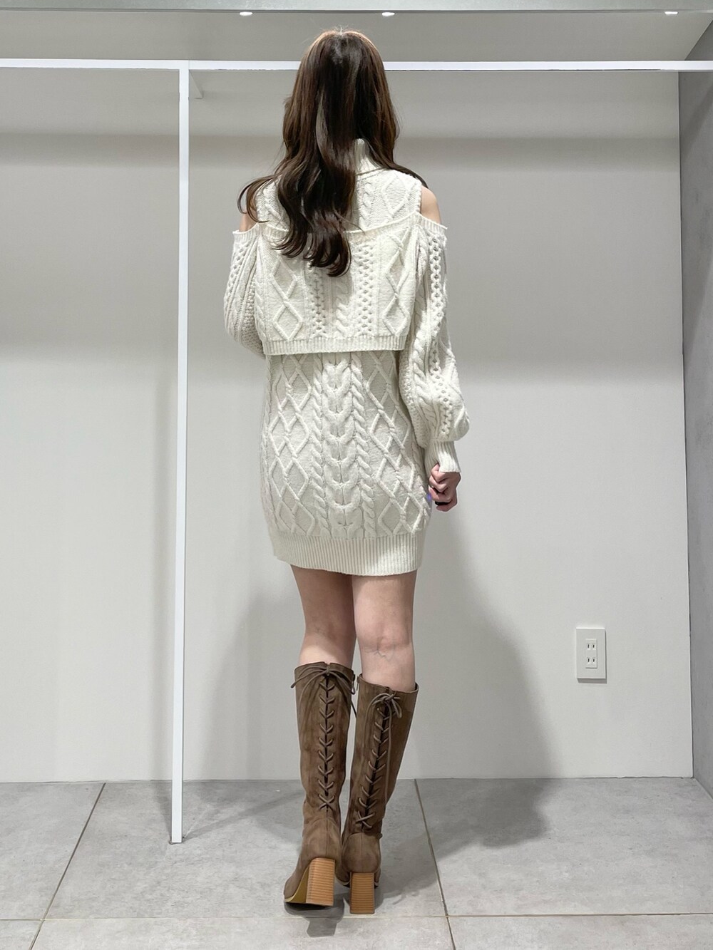 ホワイト系のその他アウター、ホワイト系のワンピース、ブラウン系のブーツを着用したレディースの冬コーディネートの9枚目の写真
