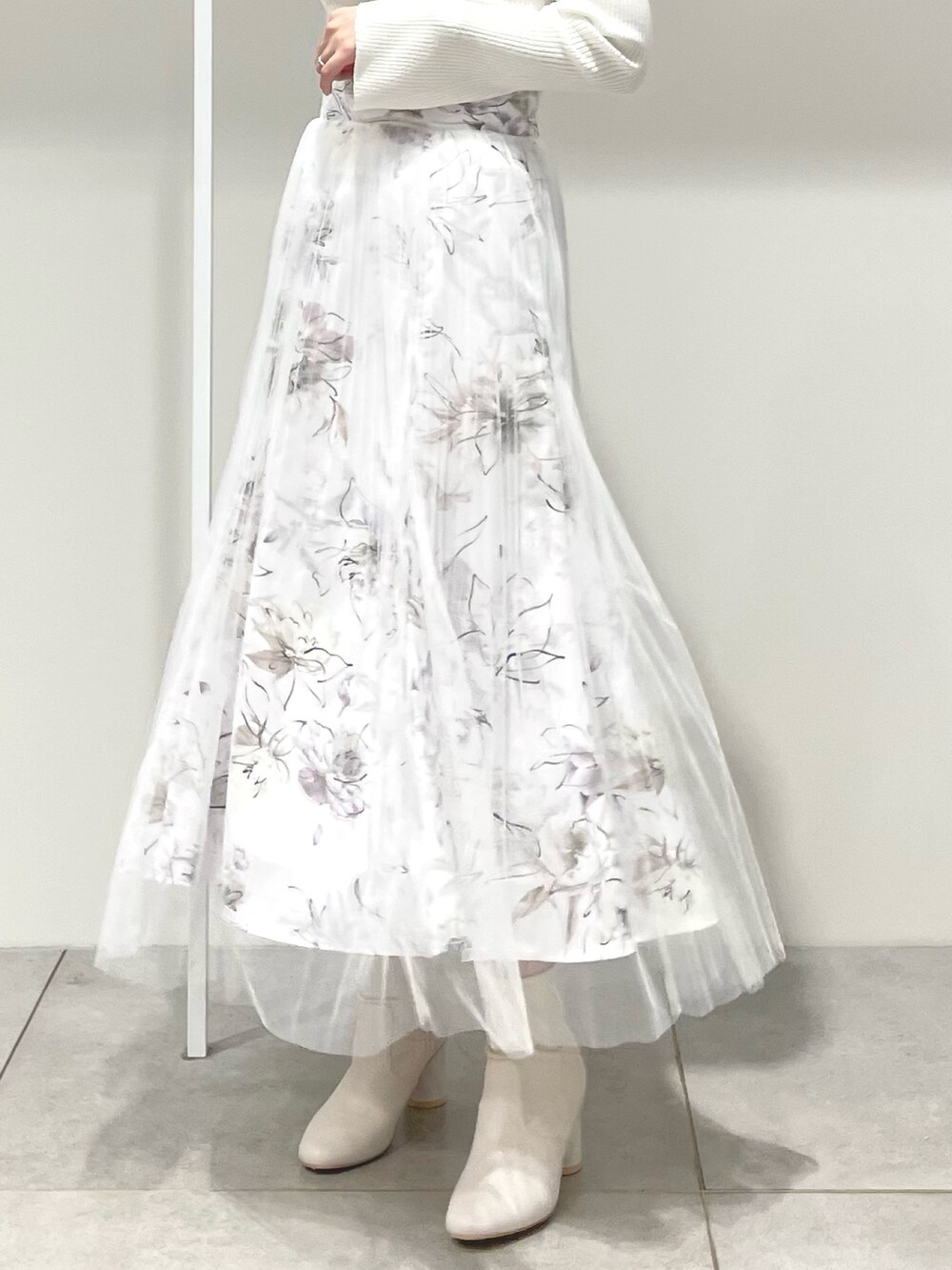 パープル系のトレンチコート、ホワイト系のニット/セーター、ピンク系のスカートを着用したレディースの春コーディネートの8枚目の写真