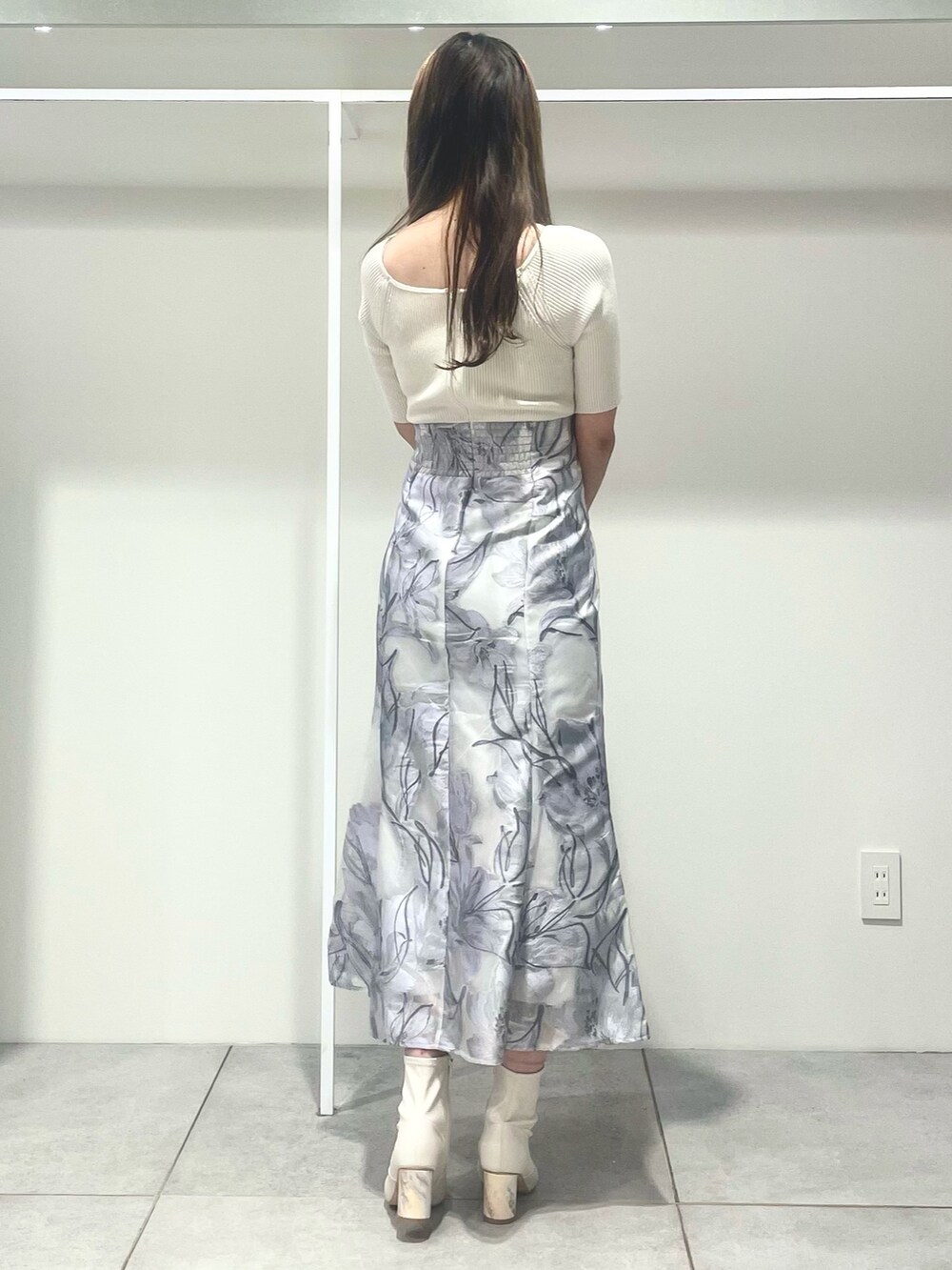 ホワイト系のトレンチコート、ホワイト系のハンドバッグ、パープル系のワンピースを着用したレディースの春コーディネートの6枚目の写真