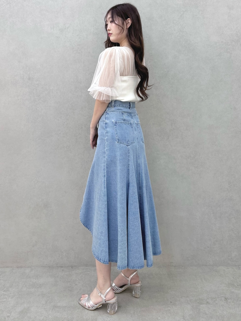 ホワイト系のニット/セーター、ブルー系のスカート、シルバー系のサンダルを着用したレディースの春コーディネートの2枚目の写真