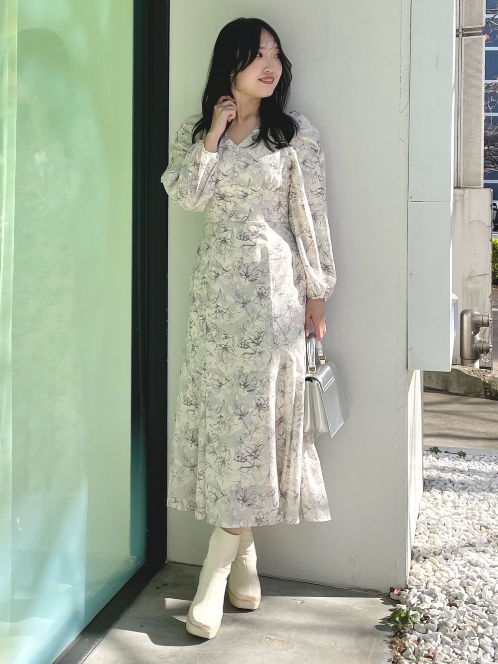 シルバー系のハンドバッグ、ホワイト系のブーツ、ホワイト系のチェスターコートを着用したレディースの冬コーディネートの6枚目の写真