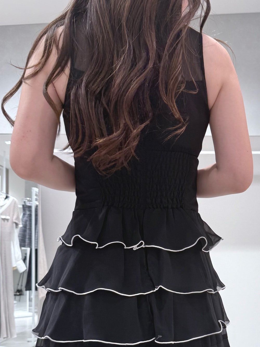 ホワイト系のハンドバッグ、ブラック系のワンピース、ホワイト系のパンプスを着用したレディースの夏コーディネートの7枚目の写真