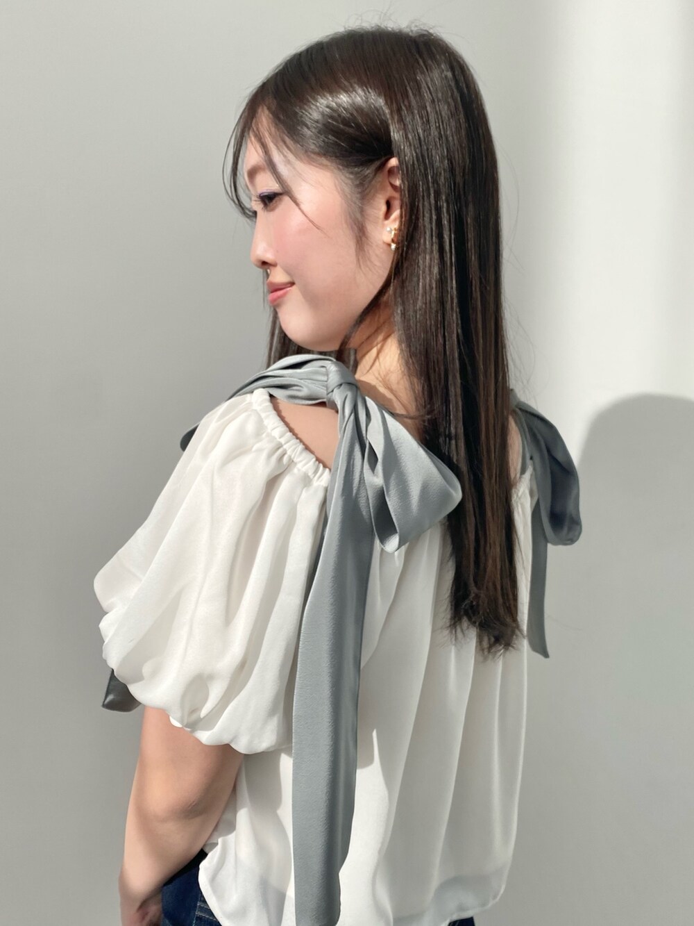 ホワイト系のシャツ/ブラウス、ブルー系のデニムパンツ、ブラック系のサンダルを着用したレディースの春コーディネートの5枚目の写真