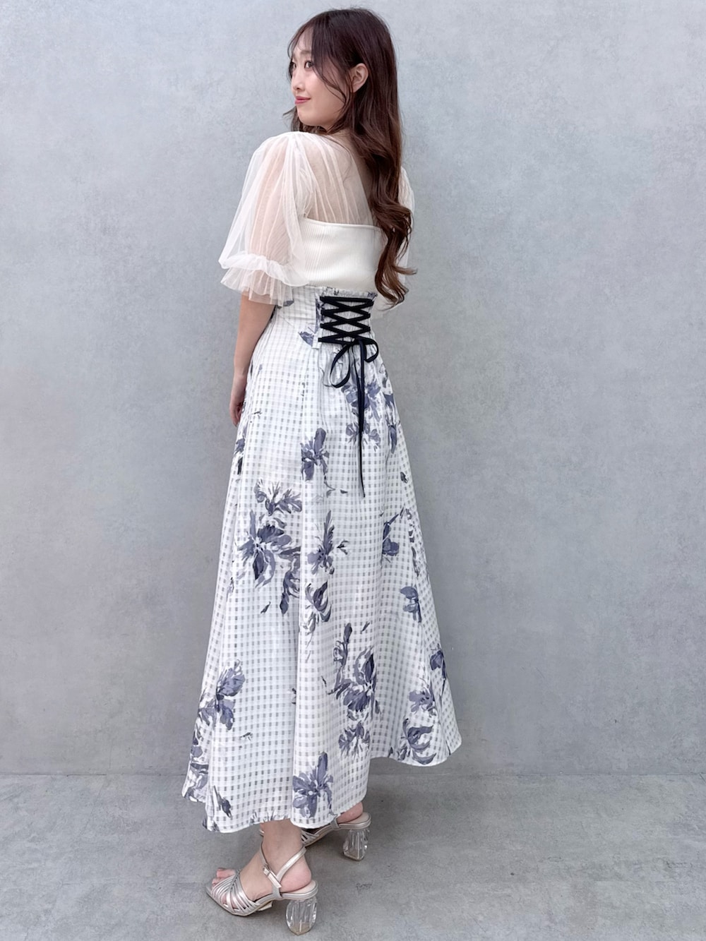 ホワイト系のニット/セーター、シルバー系のサンダル、ブルー系のスカートを着用したレディースの春コーディネートの3枚目の写真