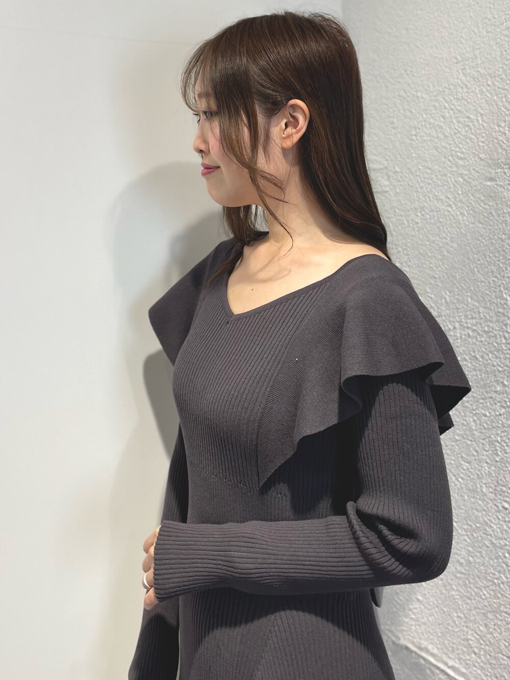 グレー系のワンピース、ブラック系のブーツを着用したレディースの冬コーディネートの4枚目の写真