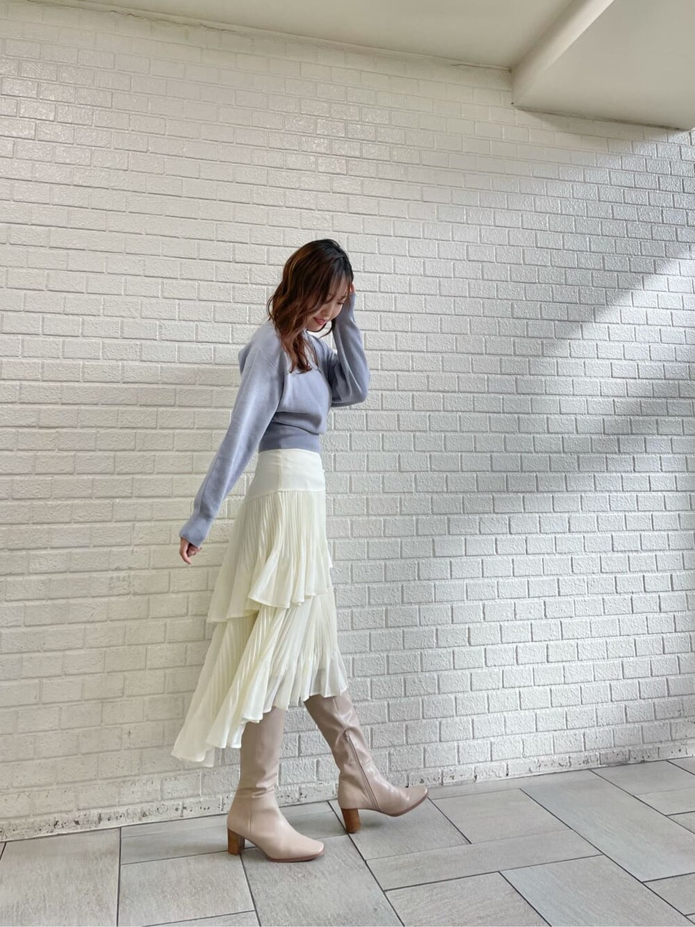 ベージュ系のブーツ、ブルー系のニット/セーター、ホワイト系のスカートを着用したレディースの冬コーディネートの5枚目の写真