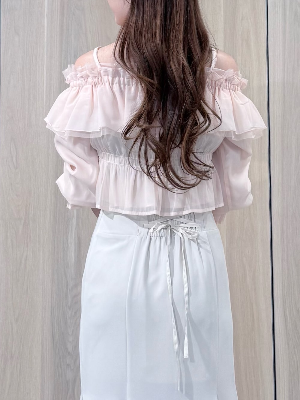 ピンク系のシャツ/ブラウス、ホワイト系のスカート、ホワイト系のパンプスを着用したレディースの春コーディネートの7枚目の写真