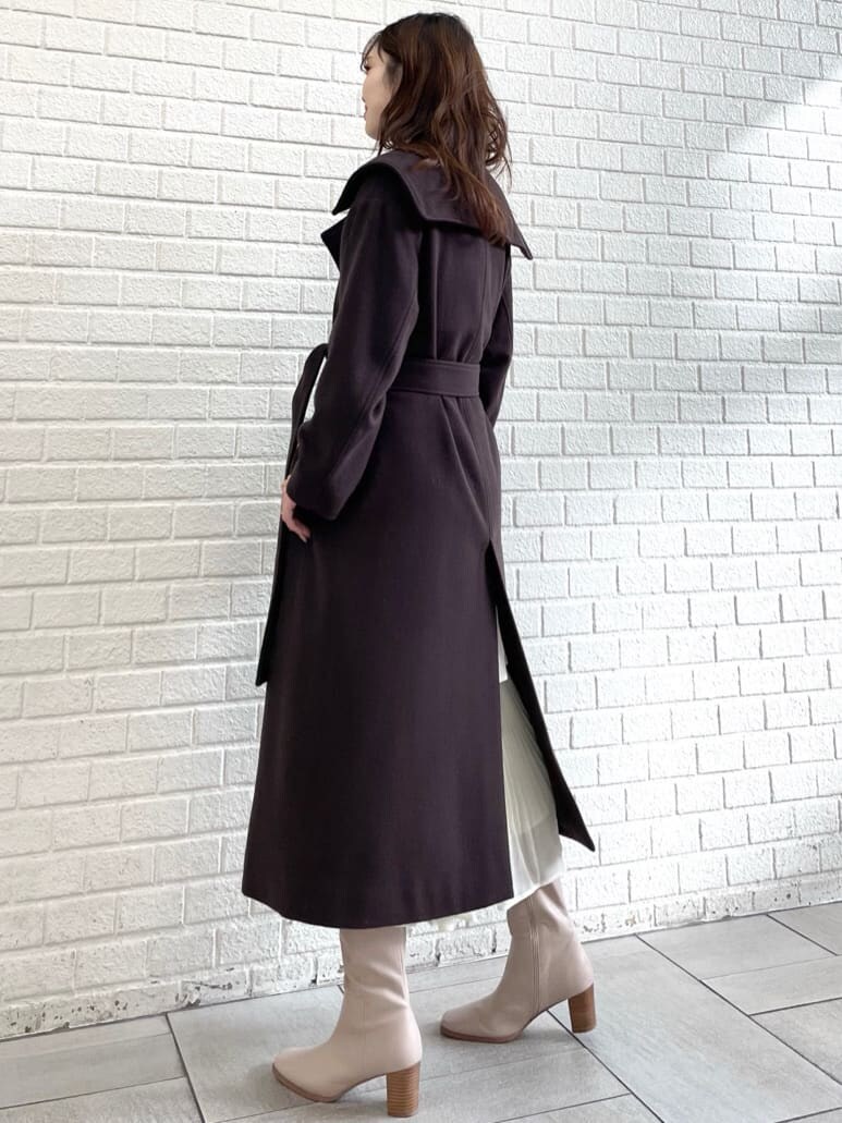 ブラウン系のチェスターコートを着用したレディースの冬コーディネートの2枚目の写真