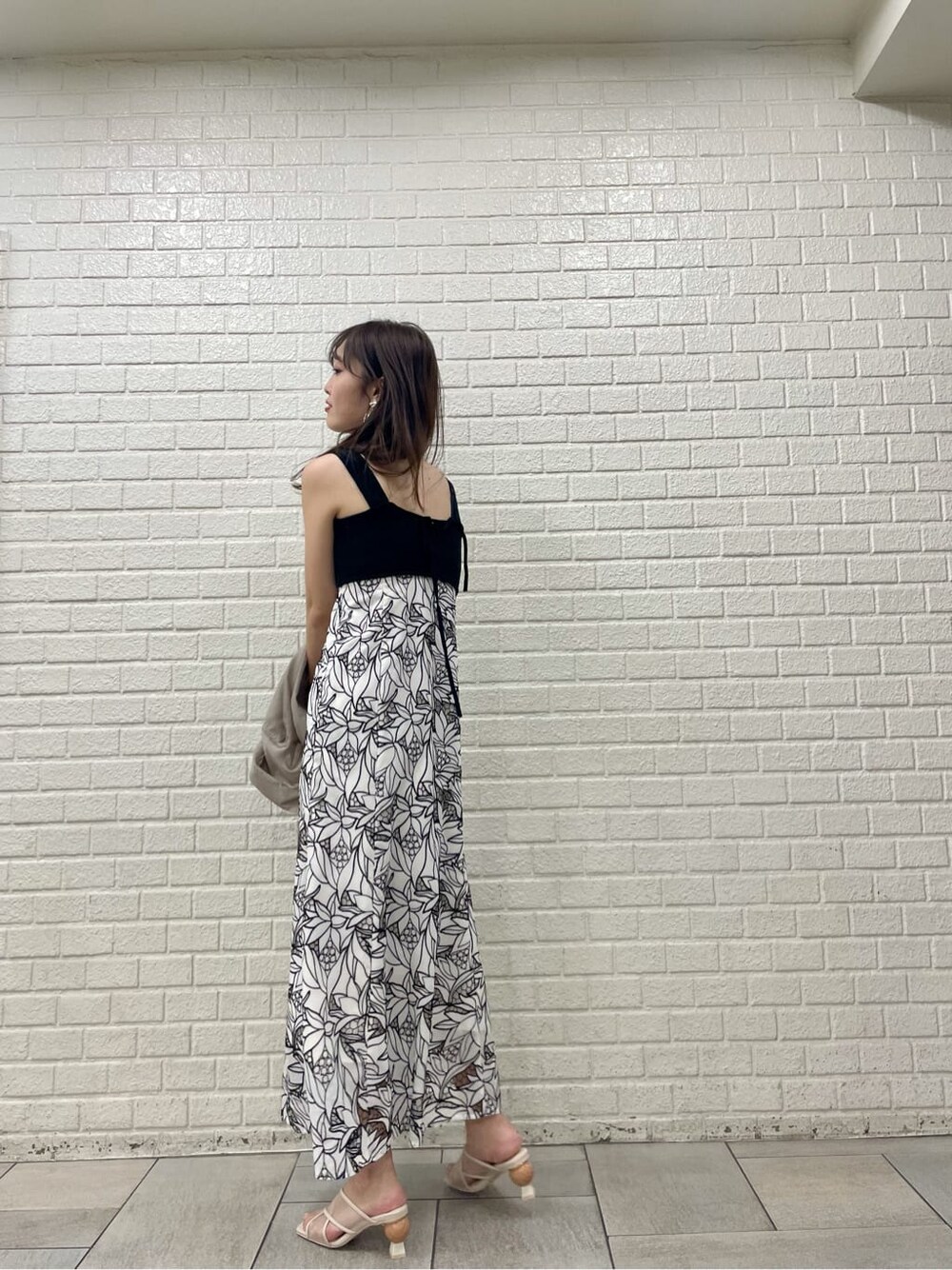 ベージュ系のサンダル、ブラック系のワンピース、ベージュ系のシャツ/ブラウスを着用したレディースの夏コーディネートの5枚目の写真